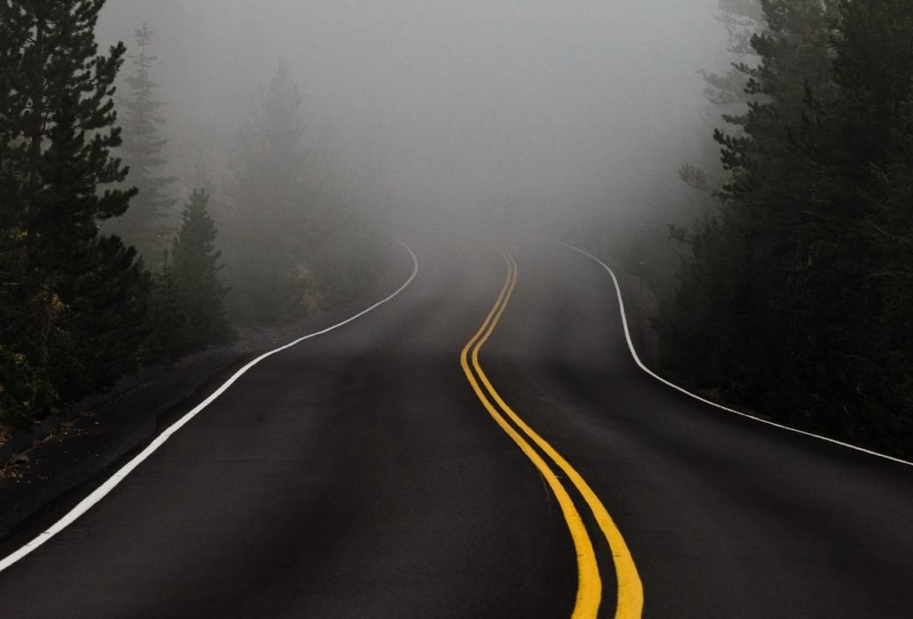 Imagem de uma estrada vazia com neblina ao fundo