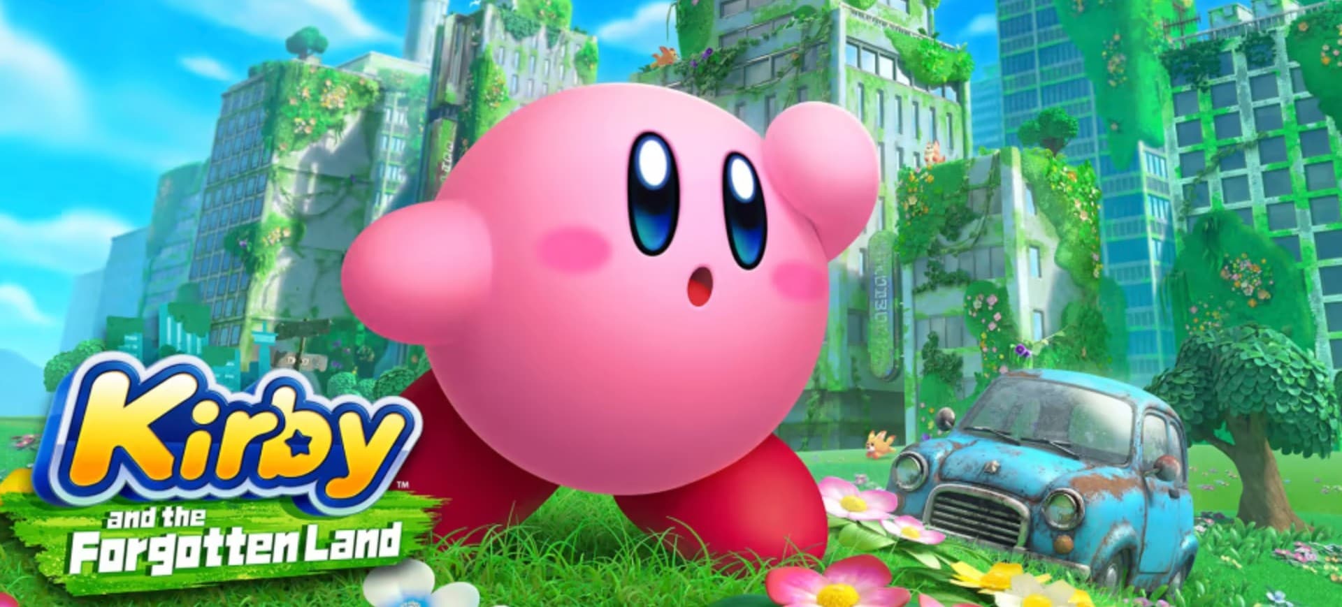 Imagem mostra o pôster de lançamento de Kirby and the Forgotten Land, jogo da Nintendo para Switch; à frente é possível ver o Kirby e, ao fundo, um cenário com prédios e um carro velho abandonado