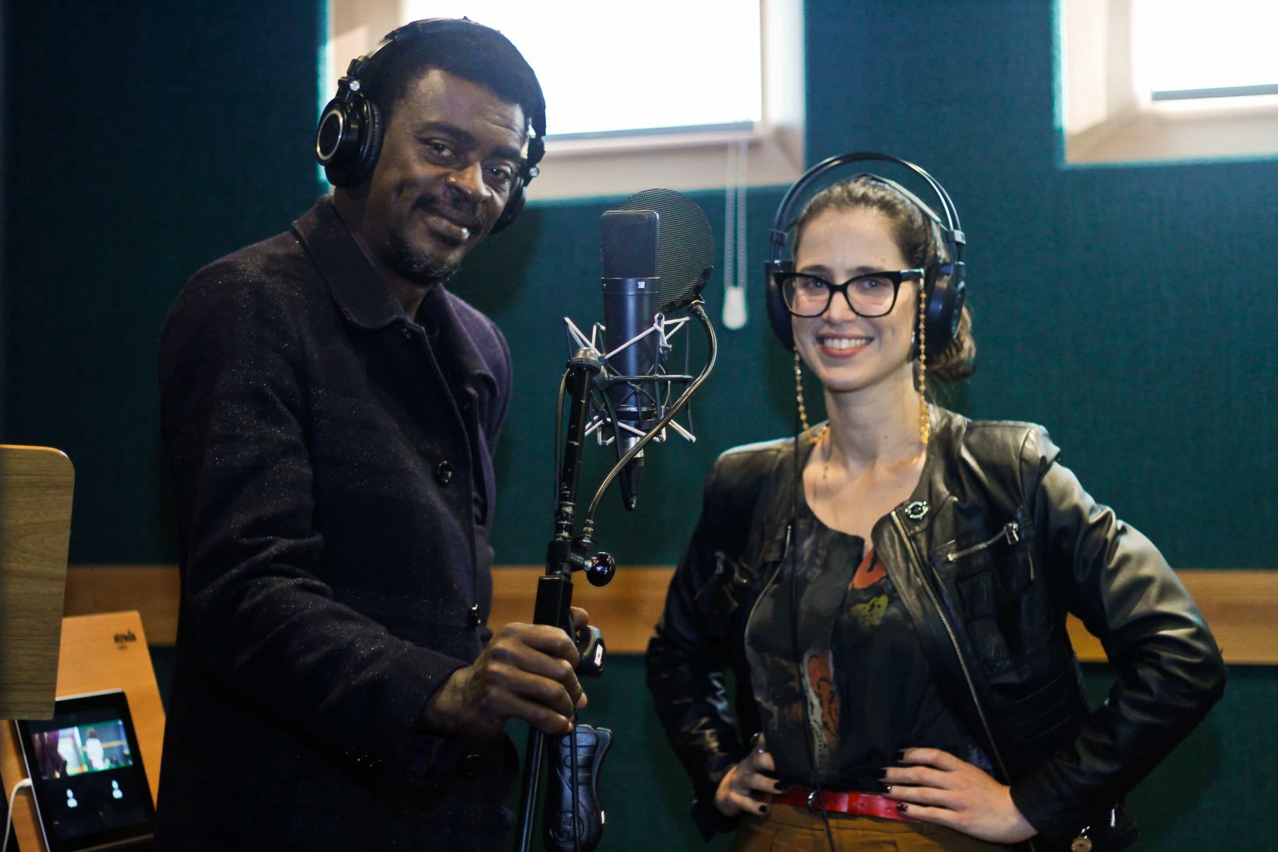 À esquerda, o ator e cantor Seu Jorge, à direita a atriz Mel Lisboa, ambos em um estúdio de gravação da audiossérie Paciente 63, Original do Spotify que volta com a Temporada 2 em fevereiro de 2022