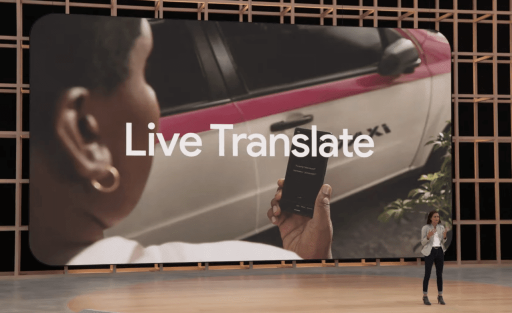 Imagem mostra executiva do Google no palco do evento Google I/O 2022, falando sobre os recursos do Pixel 6A; no telão atrás é possível ver uma moça segurança um smartphone e, ao seu lado, um táxi