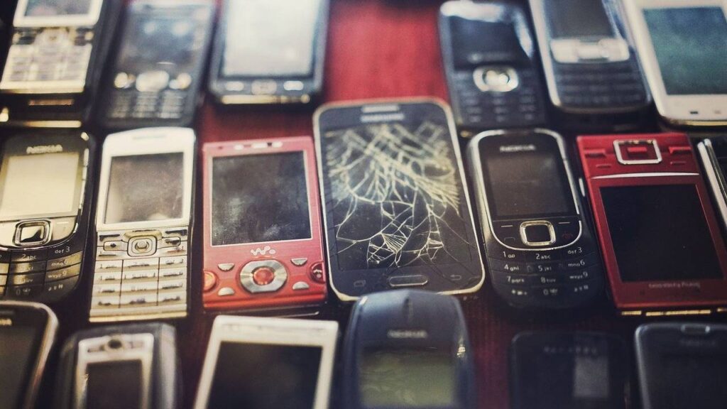 Imagem mostra celulares descartados, um tipo comum de lixo eletrônico que a economia circular visa reduzir