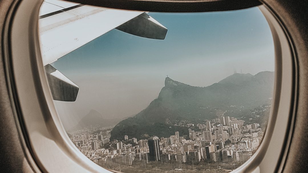 Foto da vista de uma janela de avião, para representar agências de viagem e turismo online