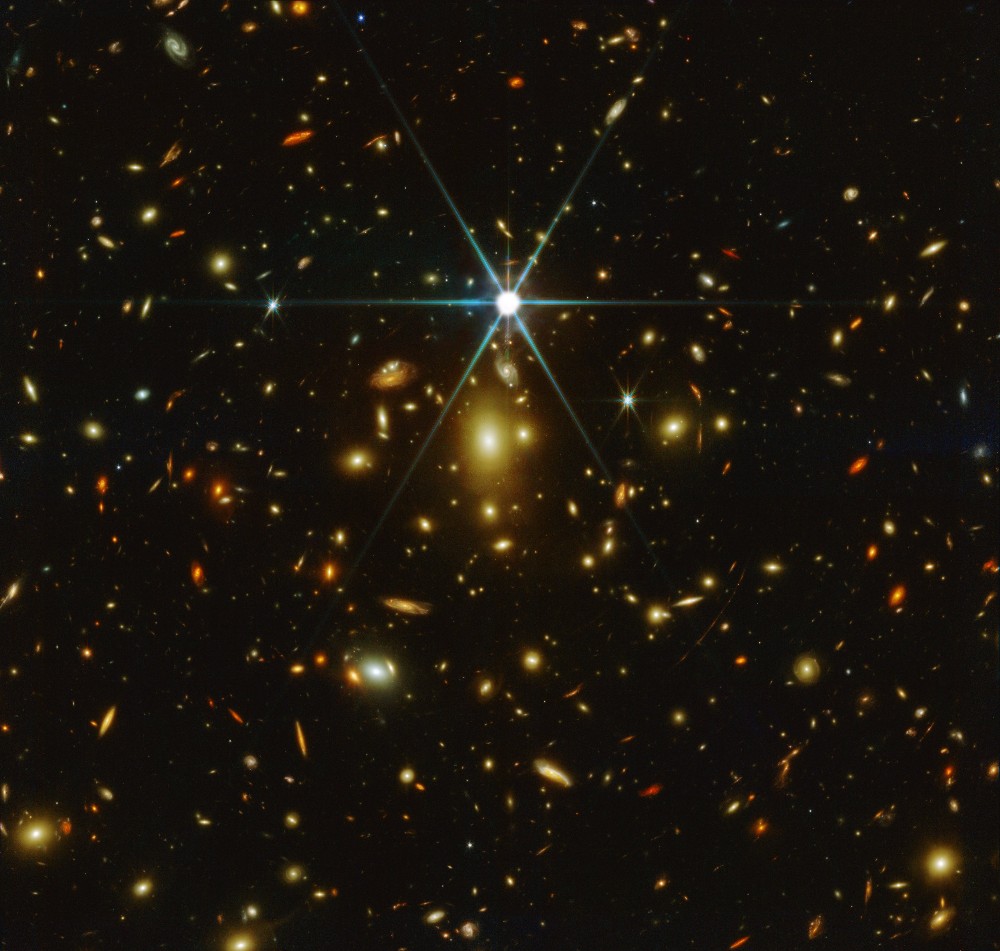 Imagem mostra milhares de pontos brilhantes que são galáxias no espaço e, no meio disso, está Earendel, a estrela mais distante e mais antiga já descoberta