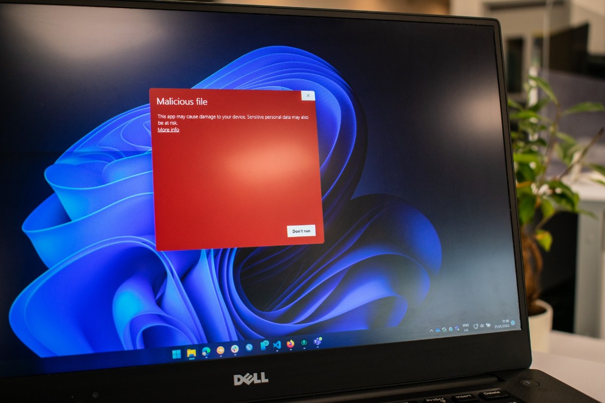 Imagem mostra uma tela de computador com um alerta em vermelho, avisando sobre um malware detectado e simbolizando ataques hackers