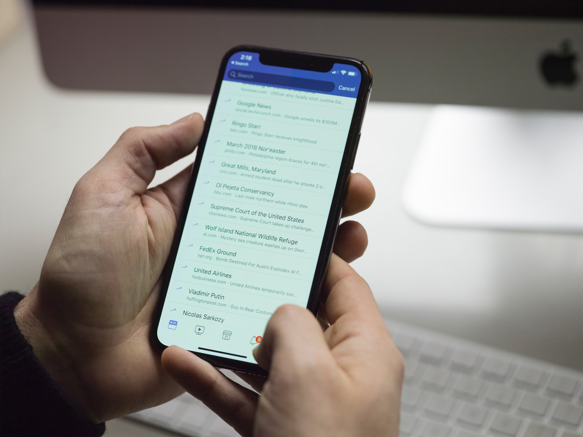 Imagem mostra um celular exibindo uma lista de notícias por uma rede social