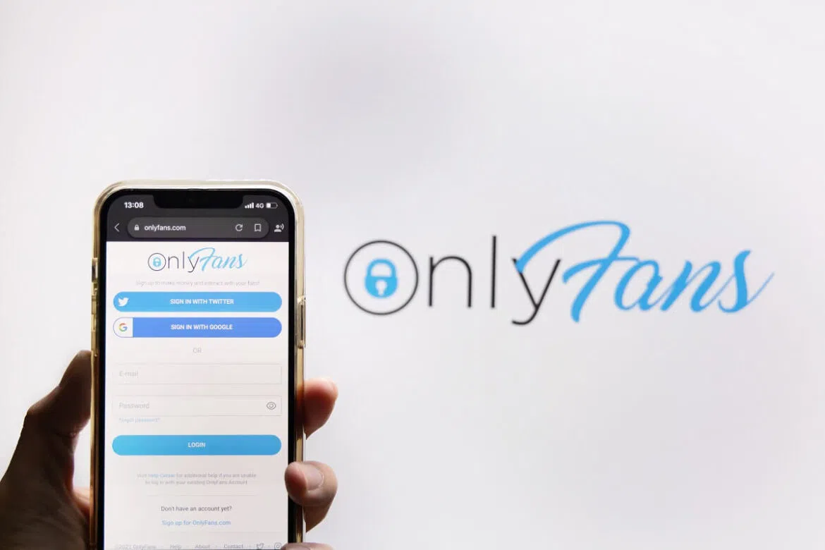 Imagem mostra a logomarca do OnlyFans com um celular aberto na página inicial da plataforma