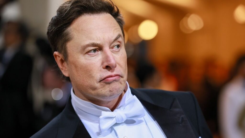 Imagem mostra o bilionário Elon Musk, dono do Twitter, olhando para o canto da câmera como se suspeitasse de alguma coisa