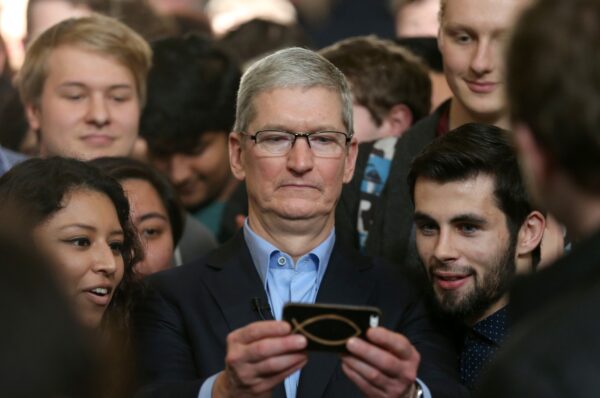 O CEO da Apple, Tim Cook, aparece segurando um iPhone junto de vários fãs da empresa