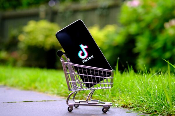 Imagem mostra um smartphone dentro de um carrinho de compras, com o logotipo do TikTok na tela do aparelho