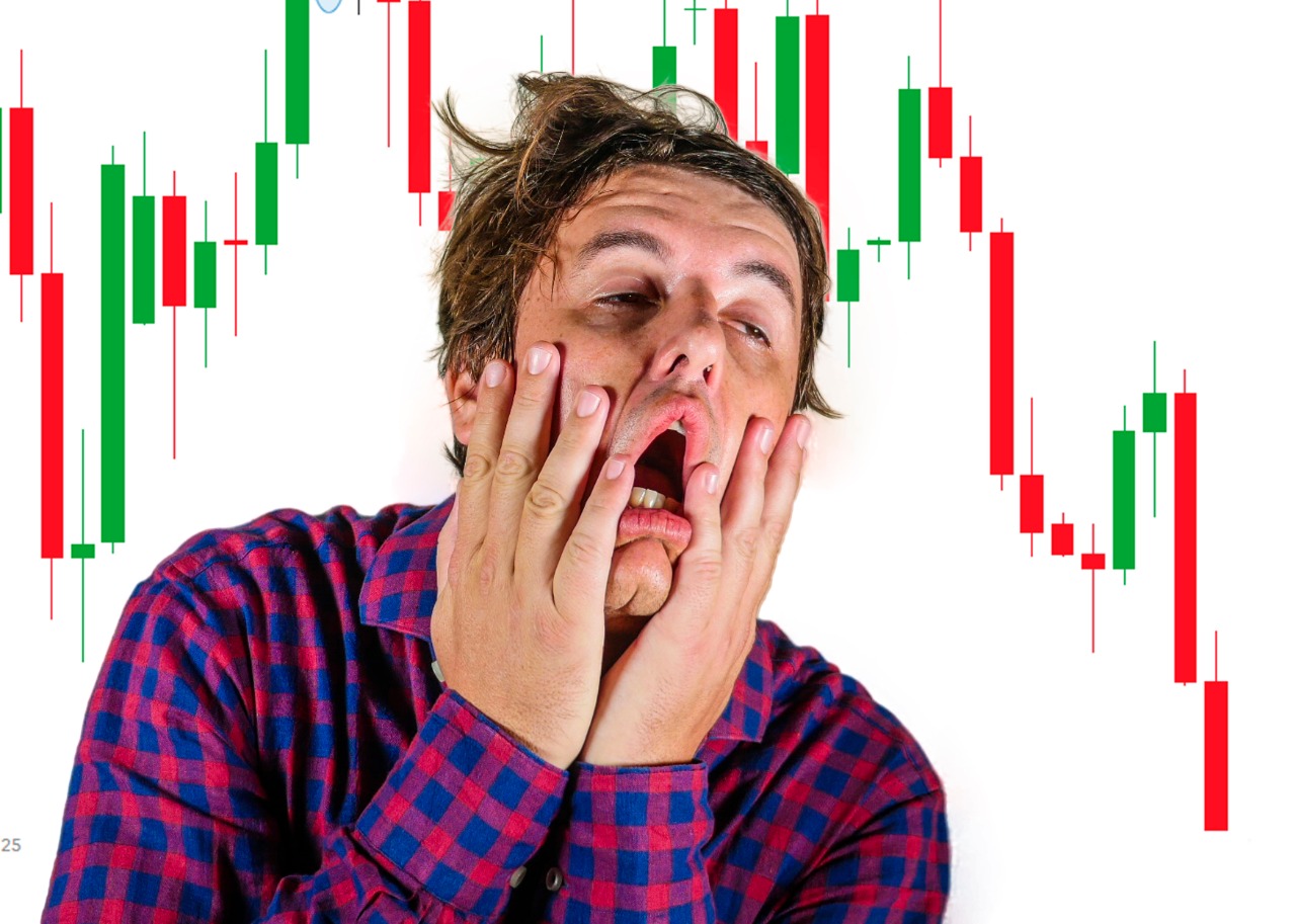 Imagem mostra investidor desesperado à frente de vários gráficos financeiros em queda