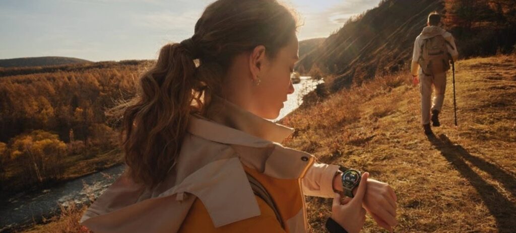 Mulher aparece de perfil em paisagem ao ar livre, mostrando em seu pulso o relógio inteligente Huawei Watch GT3 SE