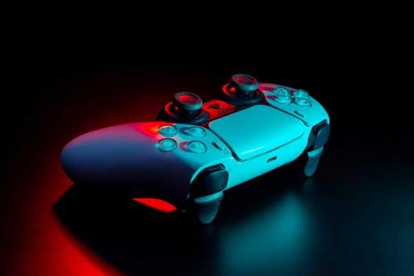 Imagem mostra o controle DualSense, do PlayStation 5, em ambiente de pouca luz
