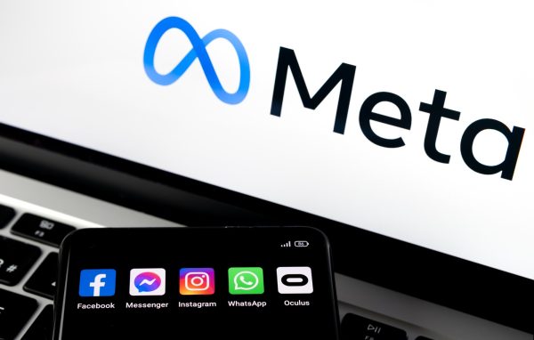 Imagem mostra o logotipo da Meta em um computador, com um smartphone ao lado listando todos os apps da empresa