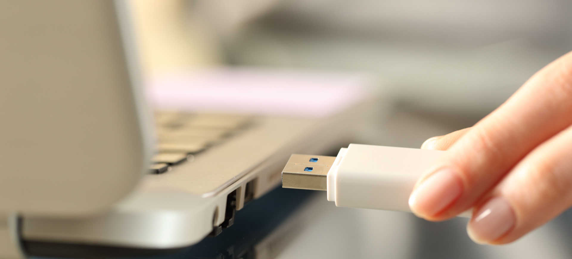 Imagem de pen-drive sendo inserido em uma entrada USB de um notebook para ilustrar a matéria sobre pen-drive explosivo