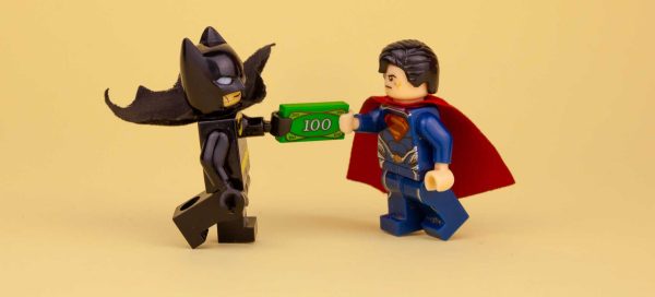 Na imagem, dois bonecos de LEGO - um do Batman e outro do Super-Homem, representando os filmes geeks que comumente são usados como isca para golpes online