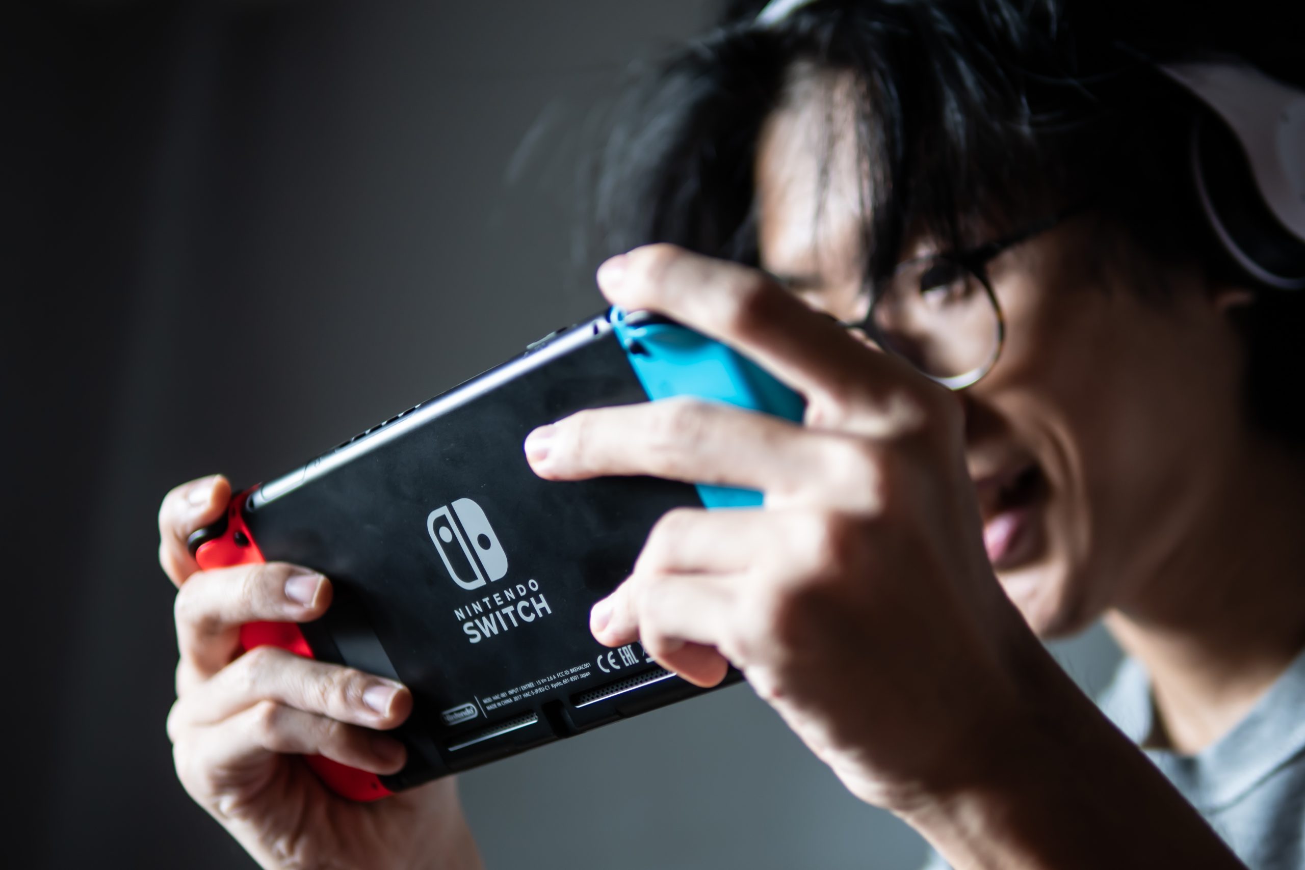 Imagem mostra jovem se divertindo com um Nintendo Switch em mãos