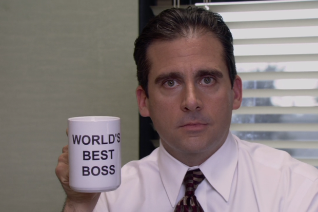 Steve Carell segurando a caneca com o escrito The World Best Boss, ou O Melhor Chefe do Mundo na tradução, em uma imagem de The Office, quando ele interpreta Michael Scott