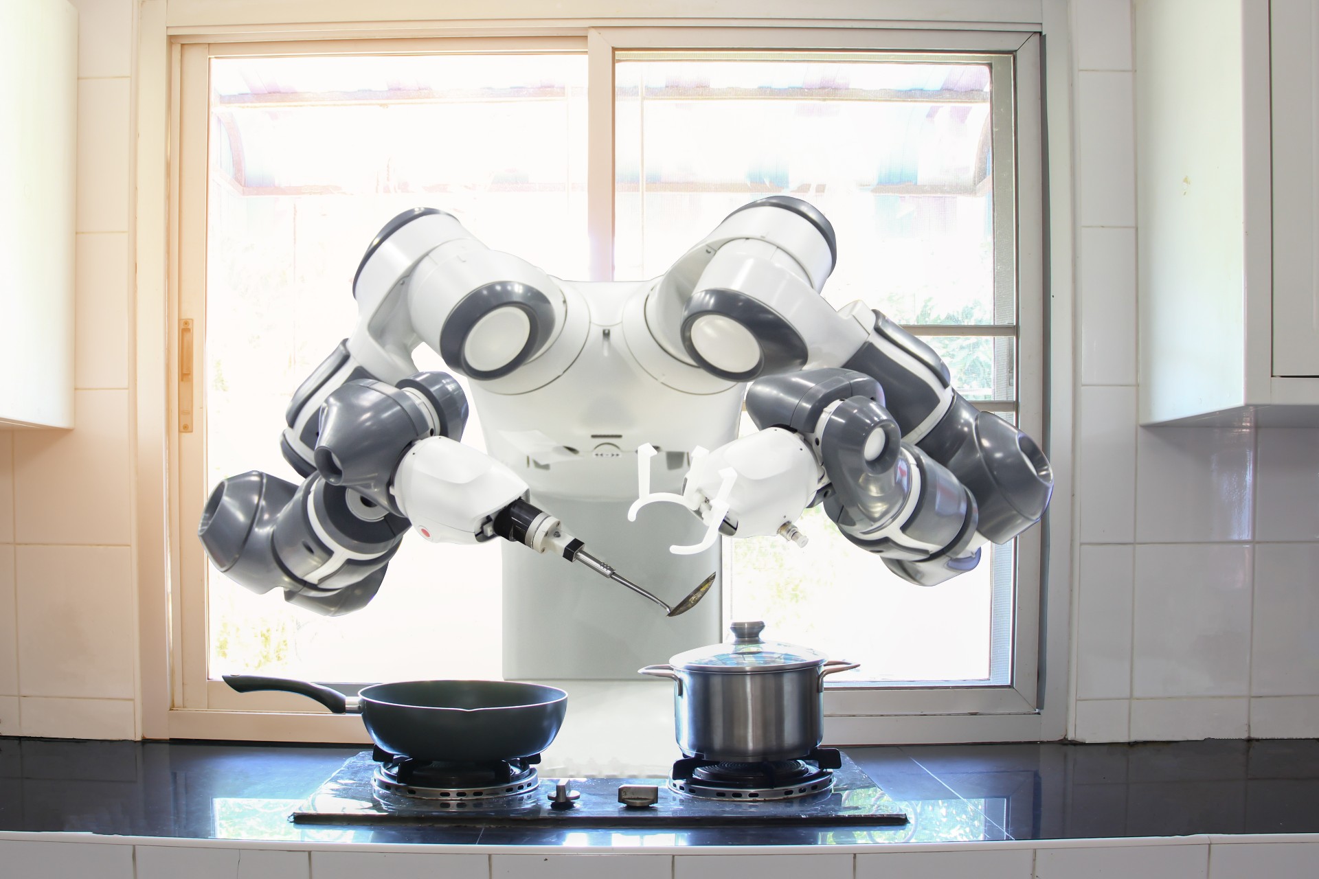 Imagem mostra um robô chef manuseando panelas na cozinha