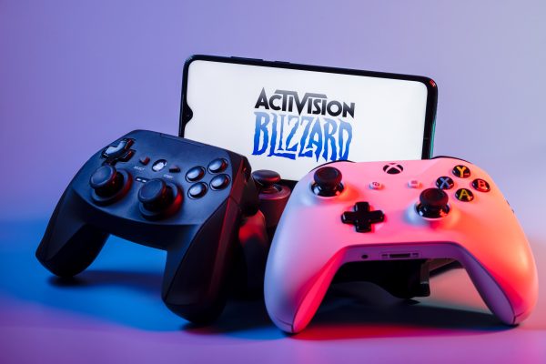 Imagem mostra um smartphone com o logotipo da Activision em meio a vários controles