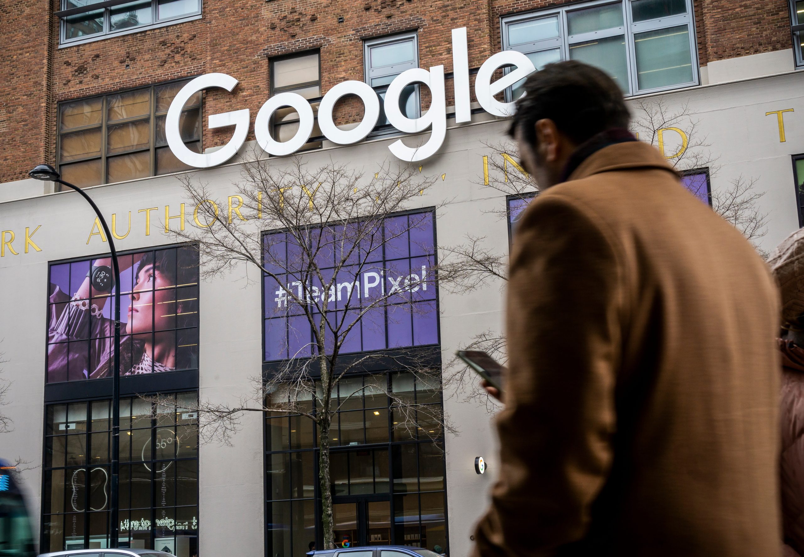 Imagem mostra fachada do Google, com uma pessoa caminhando em frente à ela