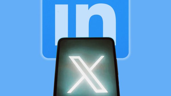 Imagem mostra o X visto de um celular apontado para o logotipo do LinkedIn ao fundo