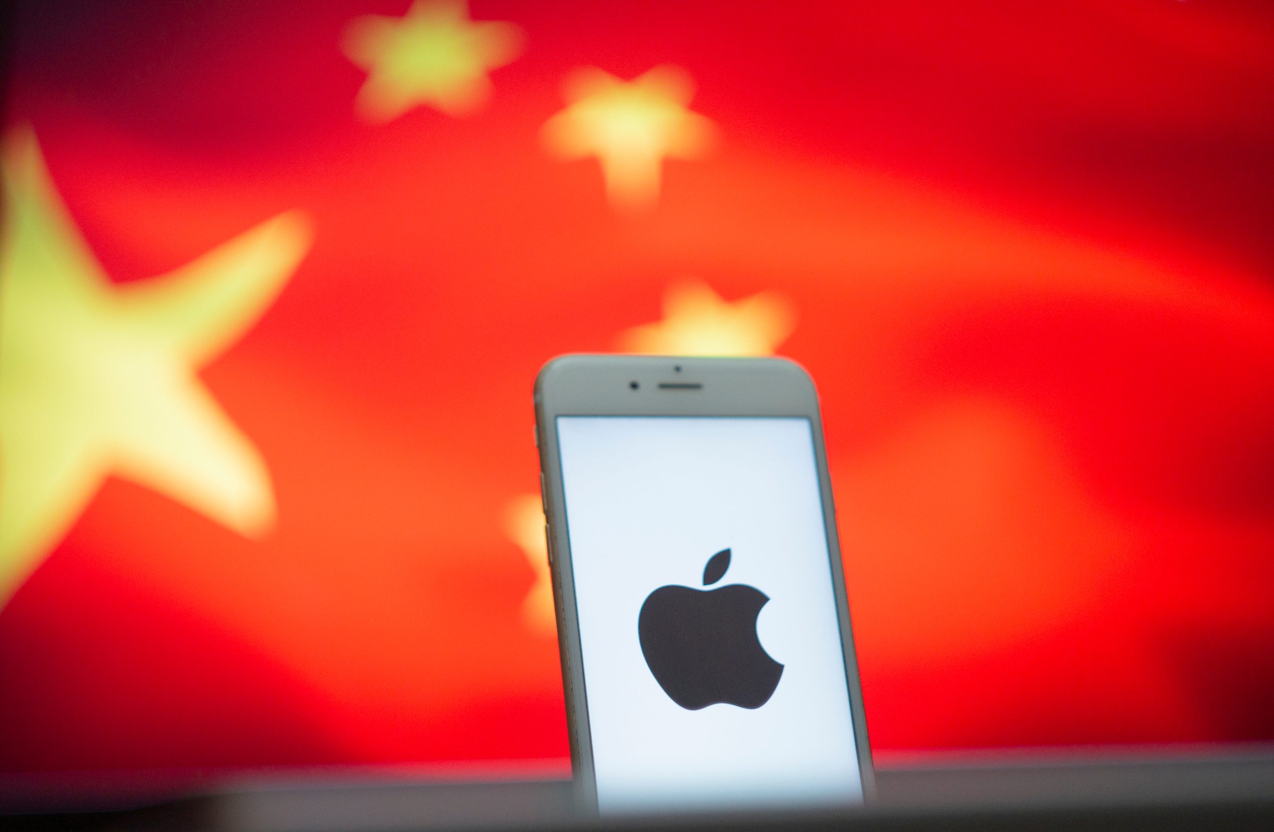 Imagem mostra um iPhone à frente de uma bandeira da China