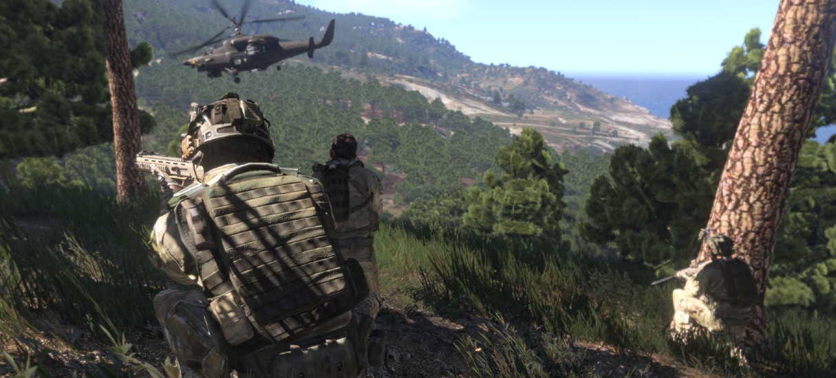 Captura de tela do jogo ARMA 3, da Bohemia Interactive. Ilustração exibe um cenário aberto e chego de árvores, com um militar à frente, de costas e carregando uma arma , enquanto outro combatente aparece mais ao fundo, à espreita; no ar um helicóptero