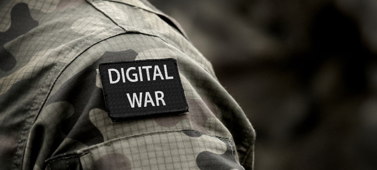 Imagem mostra um ombro com vestes militares e o inscrito "guerra digital", em alusão a conflitos que acontecem dentro de redes sociais, como a guerra entre Israel e Hamas