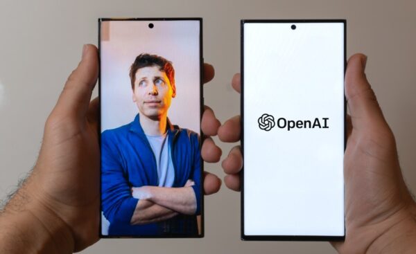 O cofundador da OpenAI, Sam Altman, em uma imagem que aparece dentro da tela de um smartphone segurado por uma mão à esquerda; à direita, outro smartphone exibe na tela o logotipo da OpenAI