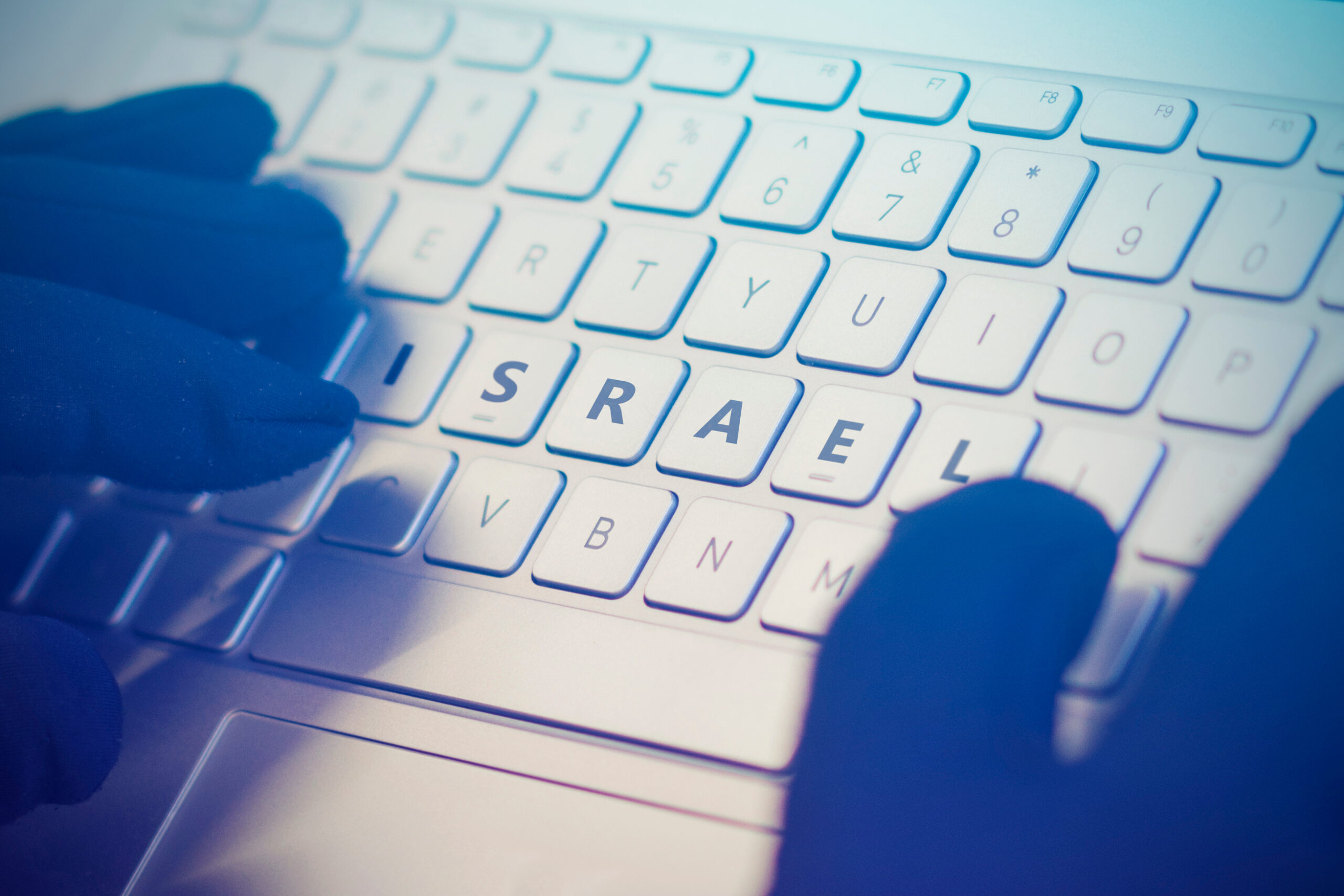 Imagem mostra dedos sobre um teclado com o nome de Israel em evidência, falando sobre ameaças cibernéticas aplicadas à guerra