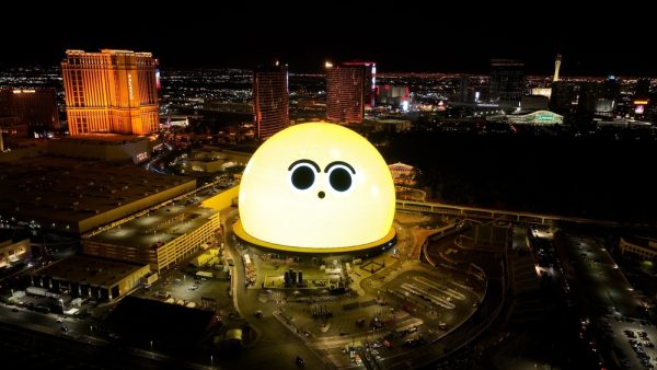 The MSG Sphere, a esfera gigante de LED em Las Vegas, nos Estados Unidos, em uma imagem tirada do alto; nos painéis aparece olhos de desenhos em fundo amarelo, como se fossem um personagem de desenho animado com uma expressão de espanto