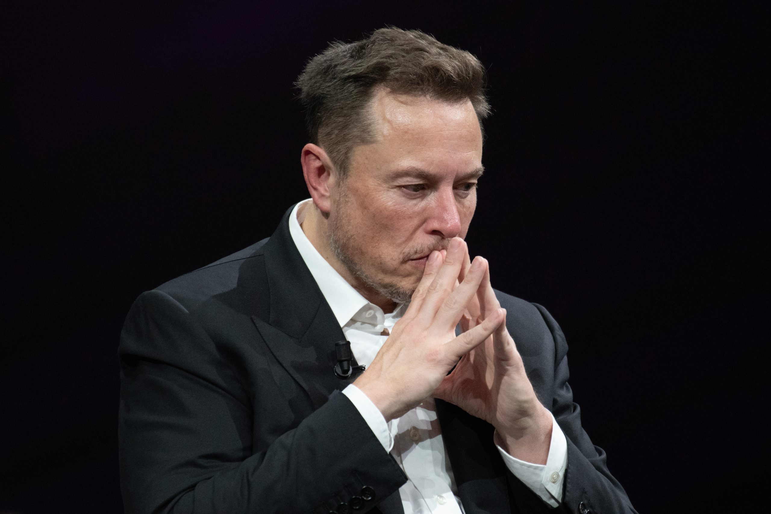 Imagem mostra o CEO da SpaceX, Elon Musk, com as mãos à frente do rosto e expressão facial pensativa